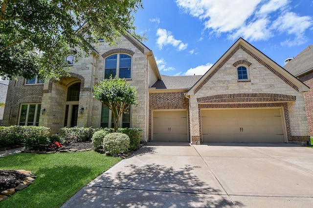 8706 Stowe Creek Ln, Missouri City, TX 77459 - french country inspired facade with stone siding, driveway, a garage, a front yard, and roof with shingles