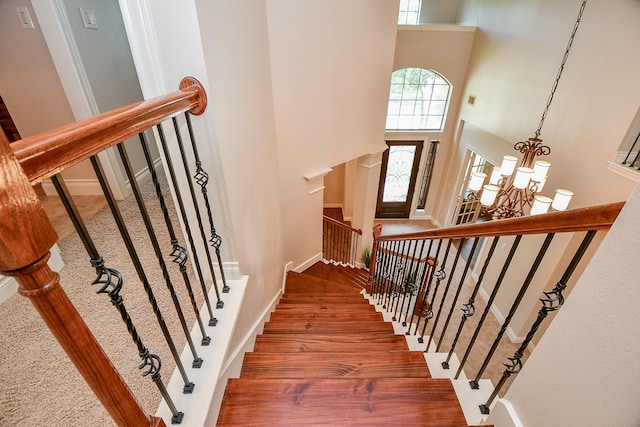 8706 Stowe Creek Ln, Missouri City, TX 77459 - stairs with a chandelier, a high ceiling, and wood finished floors