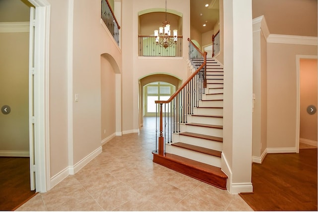 8706 Stowe Creek Ln, Missouri City, TX 77459 - foyer entrance with arched walkways, a chandelier, stairs, ornamental molding, and a towering ceiling