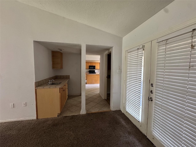 3 Ridgeline Ct, The Woodlands, TX 77381 - interior space with vaulted ceiling, a textured ceiling, light tile patterned floors, and light carpet