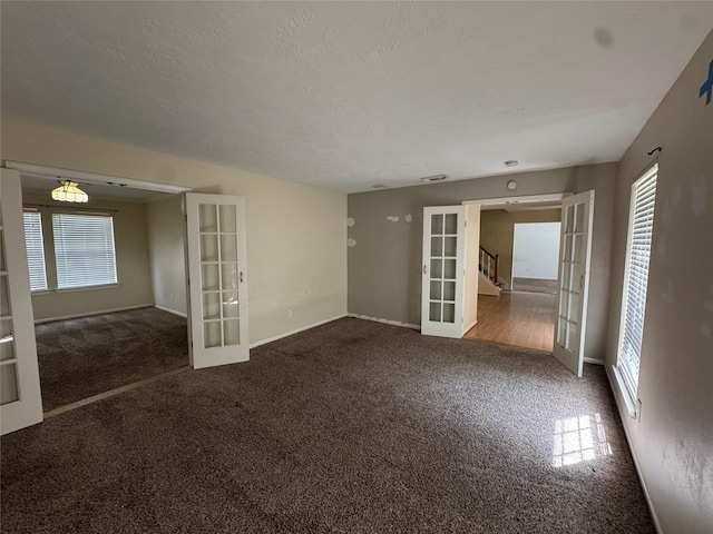 3 Ridgeline Ct, The Woodlands, TX 77381 - carpeted empty room featuring french doors, plenty of natural light, stairs, and a textured ceiling