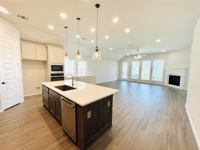 669 Cape Capri Dr, Katy, TX 77493 - kitchen with appliances with stainless steel finishes, a ceiling fan, lofted ceiling, light wood-type flooring, and a fireplace