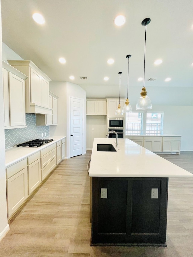 669 Cape Capri Dr, Katy, TX 77493 - kitchen with stainless steel appliances, tasteful backsplash, recessed lighting, a center island with sink, and light countertops