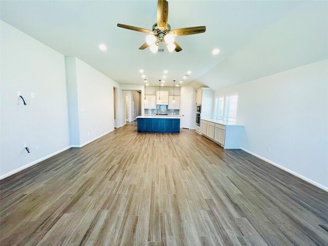669 Cape Capri Dr, Katy, TX 77493 - unfurnished living room featuring a ceiling fan, light wood finished floors, recessed lighting, and vaulted ceiling