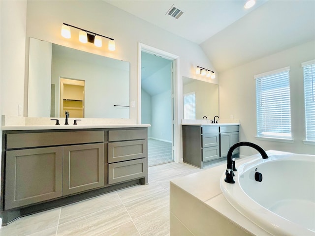 669 Cape Capri Dr, Katy, TX 77493 - bathroom with lofted ceiling, two vanities, and a bath