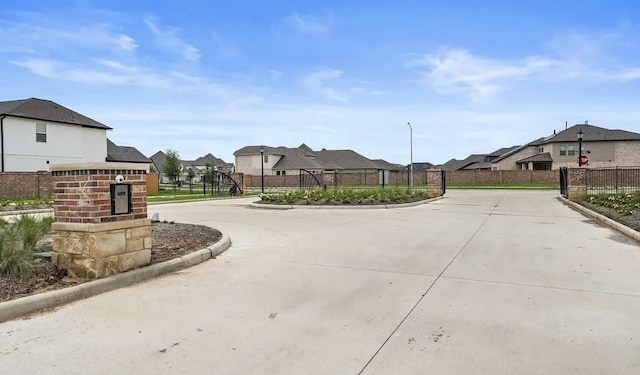 669 Cape Capri Dr, Katy, TX 77493 - view of concrete road with curbs, a residential view, traffic signs, and a gated entry