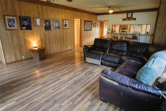 103 Birch St, Wallis, TX 77485 - living area featuring ceiling fan, wood finished floors, ornamental molding, and wooden walls