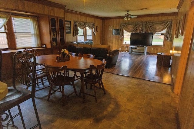 103 Birch St, Wallis, TX 77485 - dining space with wood walls, ornamental molding, ceiling fan, and tile patterned floors