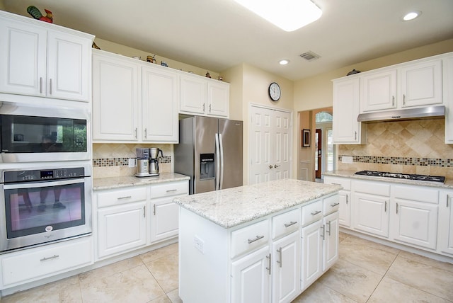 1006 Pointe Loma Dr, Sugar Land, TX 77479 - kitchen featuring appliances with stainless steel finishes, under cabinet range hood, backsplash, recessed lighting, and a kitchen island