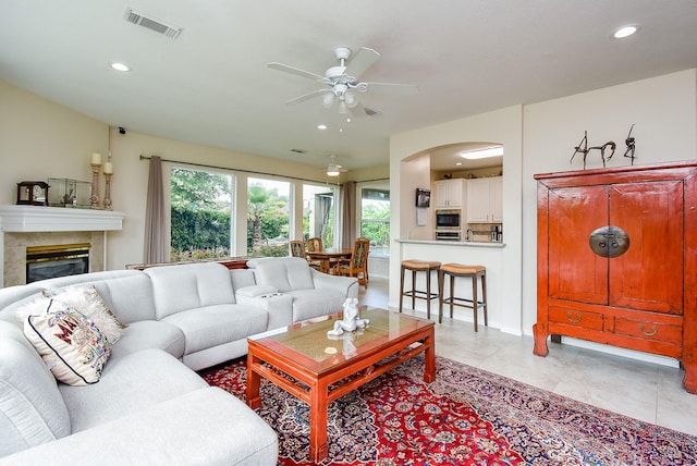 1006 Pointe Loma Dr, Sugar Land, TX 77479 - living room with ceiling fan, recessed lighting, a fireplace, arched walkways, and light tile patterned floors