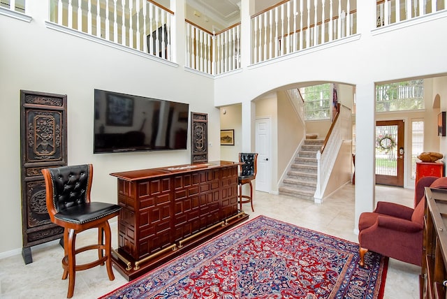 1006 Pointe Loma Dr, Sugar Land, TX 77479 - living room with arched walkways, a high ceiling, stairway, and tile patterned flooring
