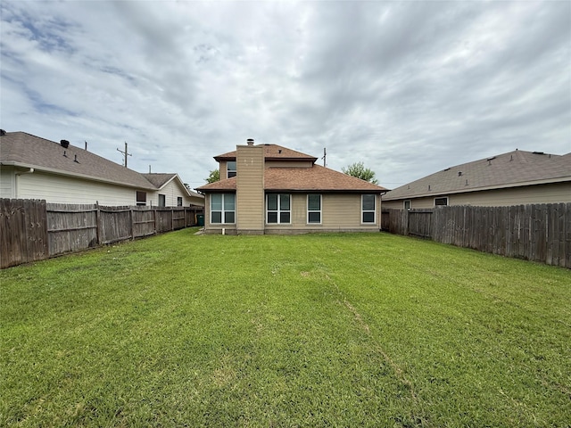 2325 Shady Tree Ln, Conroe, TX 77301 - back of house with a chimney, a fenced backyard, and roof with shingles