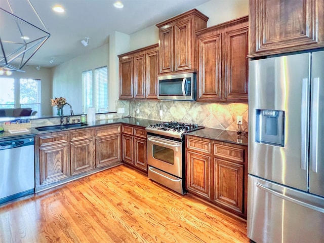 2325 Hutchins St, Houston, TX 77004 - kitchen with appliances with stainless steel finishes, light wood-style flooring, backsplash, recessed lighting, and brown cabinetry