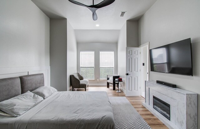 4426 Innsbrook Pl, Sugar Land, TX 77479 - bedroom with light wood-type flooring, a premium fireplace, and a ceiling fan