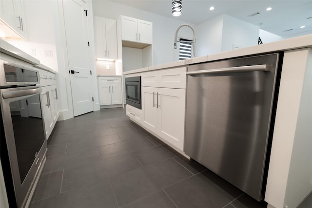 1202 Hamblen St, Houston, TX 77009 - kitchen featuring appliances with stainless steel finishes, white cabinetry, recessed lighting, light countertops, and dark tile patterned floors
