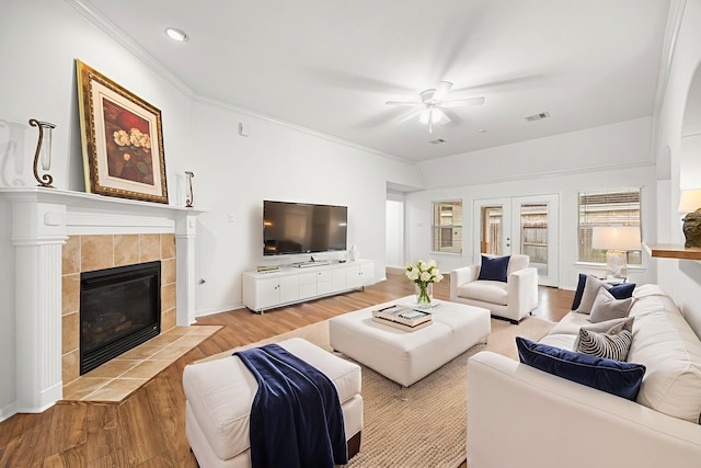 2206 Hollow Bloom Ln, Katy, TX 77494 - living room with a ceiling fan, wood finished floors, a tiled fireplace, recessed lighting, and crown molding