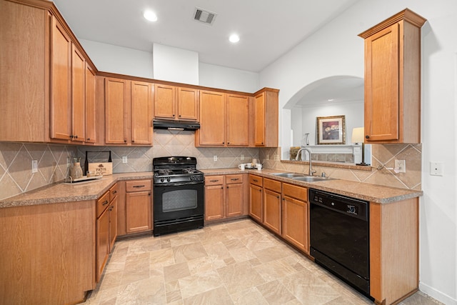 2206 Hollow Bloom Ln, Katy, TX 77494 - kitchen with black appliances, under cabinet range hood, arched walkways, backsplash, and brown cabinets