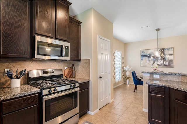8218 Rustic Cape Dr, Cypress, TX 77433 - kitchen with appliances with stainless steel finishes, dark brown cabinetry, backsplash, dark stone counters, and light tile patterned flooring