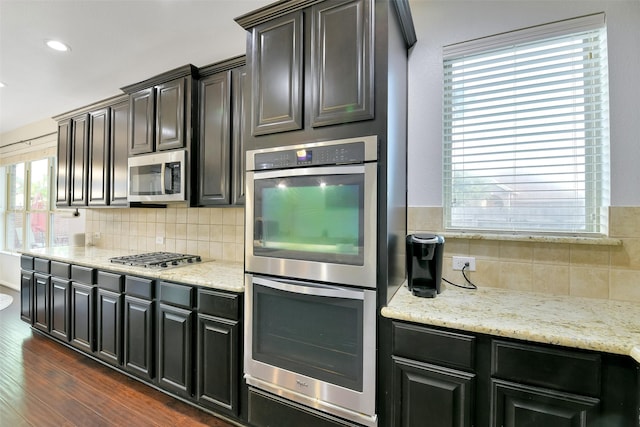 8106 Yarrow Dr, Cypress, TX 77433 - kitchen with stainless steel appliances, backsplash, dark wood finished floors, light stone countertops, and recessed lighting
