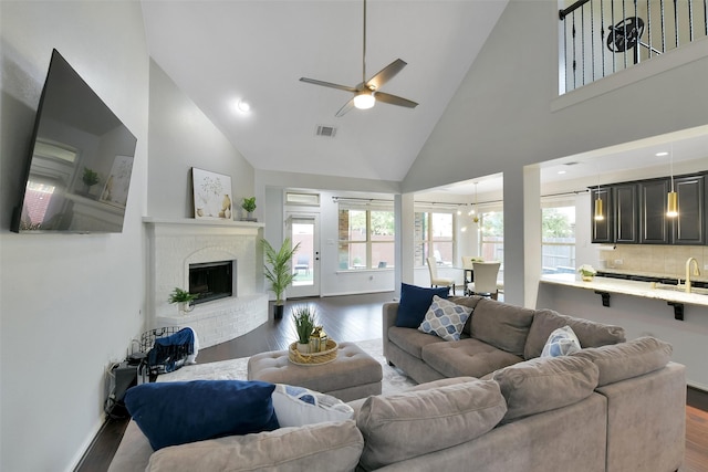 8106 Yarrow Dr, Cypress, TX 77433 - living room featuring dark wood-type flooring, high vaulted ceiling, a ceiling fan, and a fireplace
