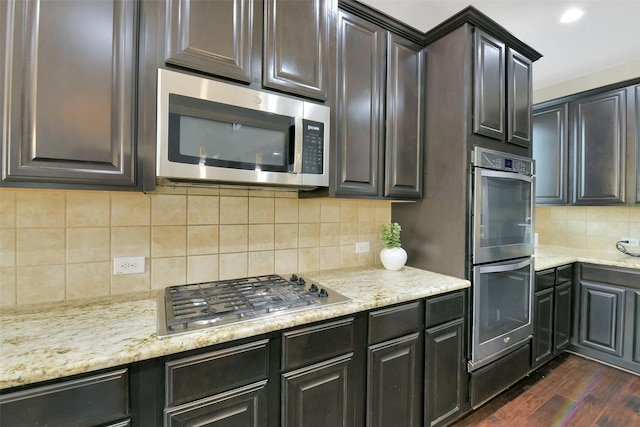 8106 Yarrow Dr, Cypress, TX 77433 - kitchen with stainless steel appliances, dark wood-type flooring, tasteful backsplash, light stone countertops, and recessed lighting
