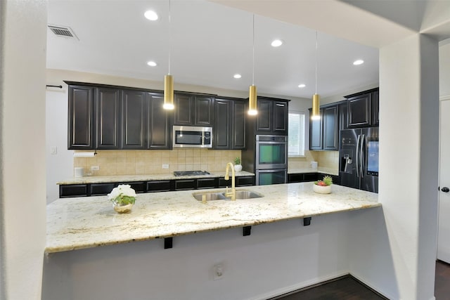 8106 Yarrow Dr, Cypress, TX 77433 - kitchen with appliances with stainless steel finishes, light stone counters, tasteful backsplash, a breakfast bar area, and recessed lighting