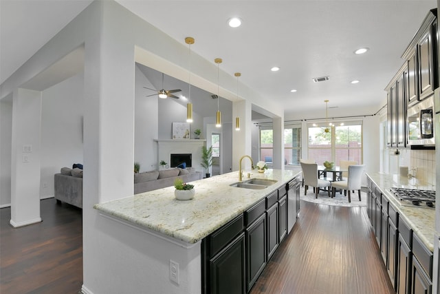 8106 Yarrow Dr, Cypress, TX 77433 - kitchen with stainless steel appliances, dark wood-type flooring, light stone countertops, a ceiling fan, and open floor plan