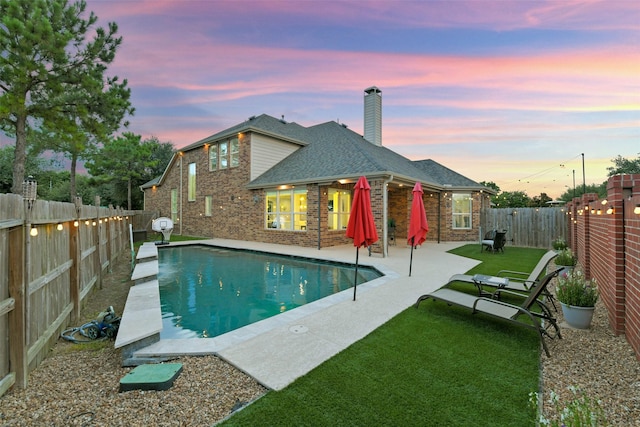 8106 Yarrow Dr, Cypress, TX 77433 - pool at dusk with a patio and a fenced backyard