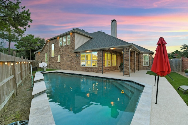 8106 Yarrow Dr, Cypress, TX 77433 - pool at dusk with a patio area and a fenced backyard