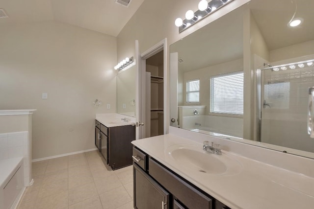 12807 Maybank Shores Ct, Houston, TX 77045 - bathroom with two vanities, a bath, a shower stall, tile patterned floors, and vaulted ceiling