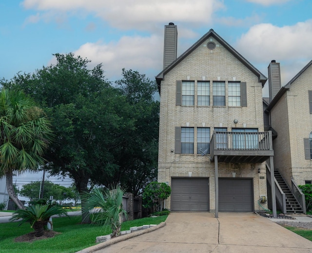2601 Sailboat Dr, Houston, TX 77058 - rear view of house featuring brick siding, driveway, an attached garage, and stairway