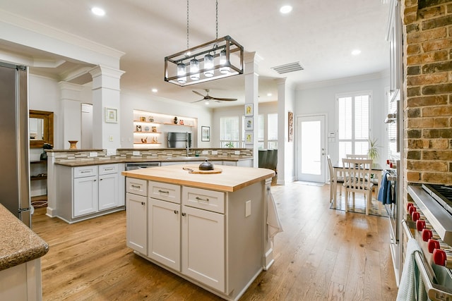 2442 Chimney Rock Rd, Houston, TX 77056 - kitchen with butcher block counters, ceiling fan, a kitchen island, stainless steel appliances, and plenty of natural light