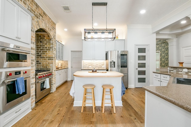 2442 Chimney Rock Rd, Houston, TX 77056 - kitchen featuring appliances with stainless steel finishes, ornamental molding, backsplash, a center island, and recessed lighting