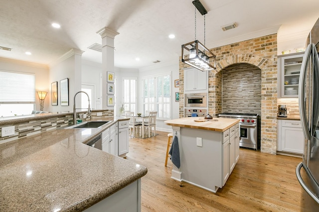 2442 Chimney Rock Rd, Houston, TX 77056 - kitchen with appliances with stainless steel finishes, wood counters, an island with sink, plenty of natural light, and recessed lighting