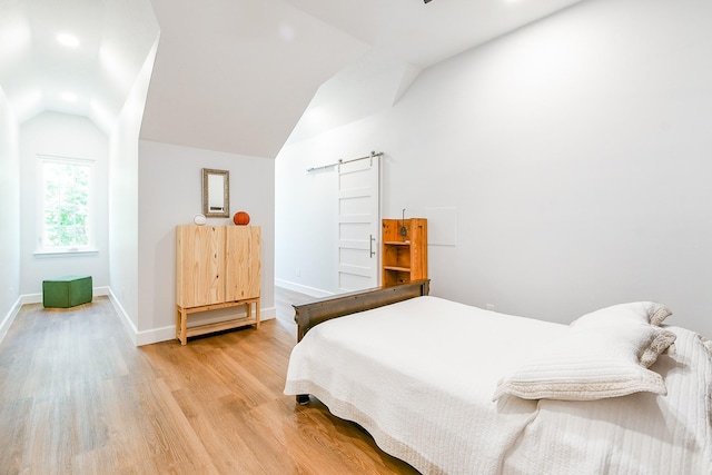 2442 Chimney Rock Rd, Houston, TX 77056 - bedroom featuring lofted ceiling, wood finished floors, and a barn door