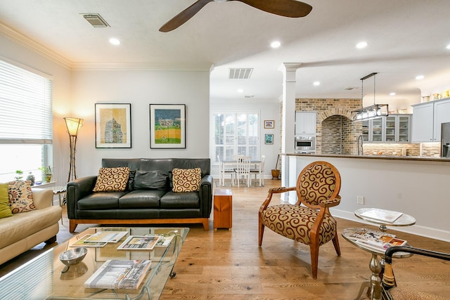2442 Chimney Rock Rd, Houston, TX 77056 - living room featuring ceiling fan, crown molding, light wood-style floors, decorative columns, and recessed lighting