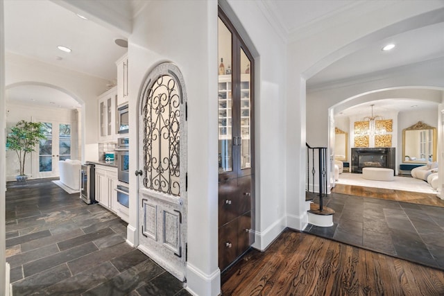 30 Hackberry Ln Unit A, Houston, TX 77027 - entryway with wine cooler, crown molding, a chandelier, arched walkways, and recessed lighting
