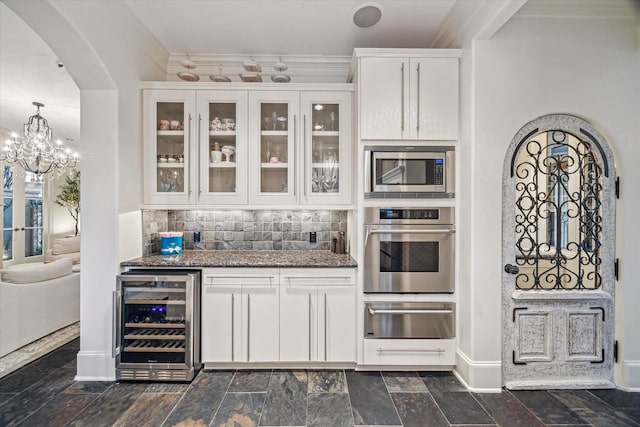 30 Hackberry Ln Unit A, Houston, TX 77027 - kitchen with beverage cooler, stainless steel appliances, a warming drawer, arched walkways, and glass insert cabinets