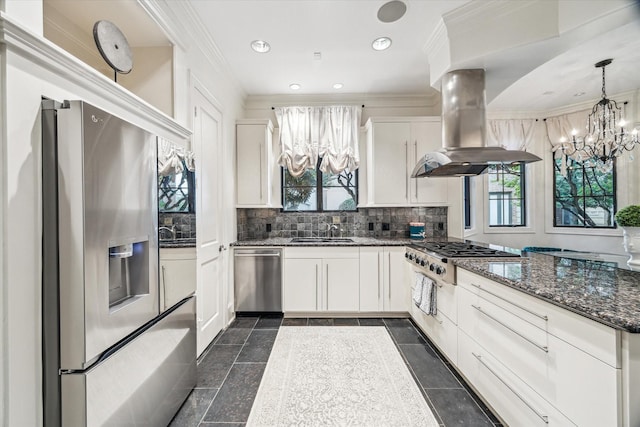 30 Hackberry Ln Unit A, Houston, TX 77027 - kitchen with stainless steel appliances, a chandelier, island range hood, plenty of natural light, and ornamental molding