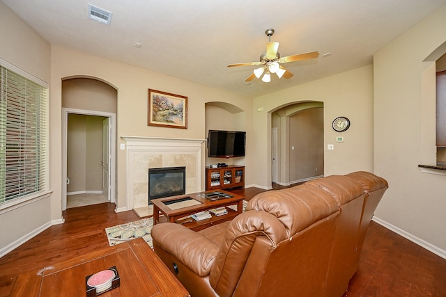 21211 Dover Park Ln, Katy, TX 77450 - living room featuring a ceiling fan, a tile fireplace, wood finished floors, and arched walkways
