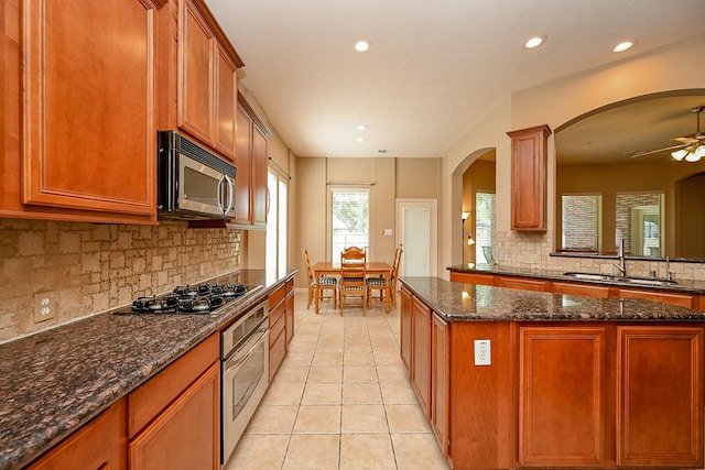 21211 Dover Park Ln, Katy, TX 77450 - kitchen with stainless steel appliances, tasteful backsplash, a ceiling fan, recessed lighting, and light tile patterned floors