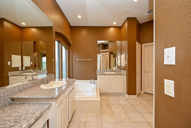 21211 Dover Park Ln, Katy, TX 77450 - full bathroom with a textured wall, a tub with jets, two vanities, tile patterned flooring, and recessed lighting