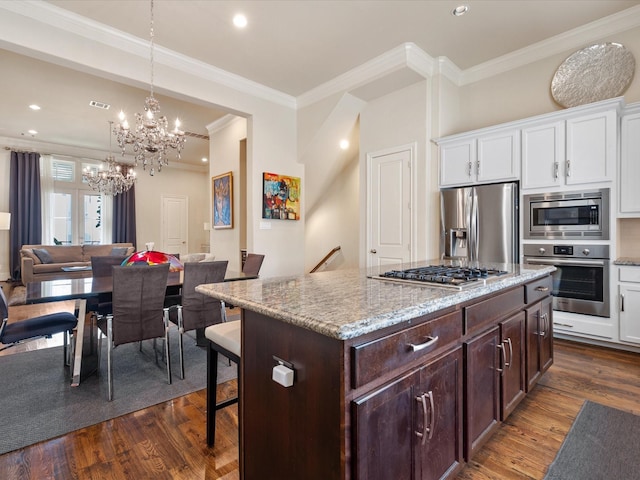 249 E 27th St, Houston, TX 77008 - kitchen featuring appliances with stainless steel finishes, white cabinetry, ornamental molding, a chandelier, and dark wood-style flooring