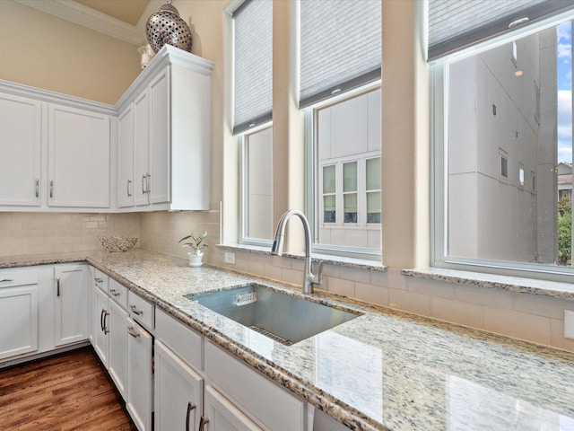 249 E 27th St, Houston, TX 77008 - kitchen featuring white cabinetry, backsplash, healthy amount of natural light, light stone countertops, and ornamental molding