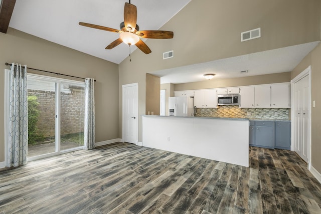 2919 Lake View Dr, Missouri City, TX 77459 - kitchen with white fridge with ice dispenser, stainless steel microwave, high vaulted ceiling, ceiling fan, and dark wood-style flooring