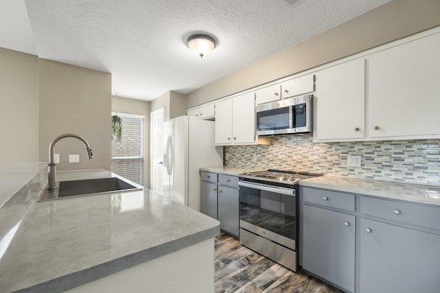 2919 Lake View Dr, Missouri City, TX 77459 - kitchen featuring stainless steel appliances, dark wood-style flooring, tasteful backsplash, white cabinets, and a textured ceiling