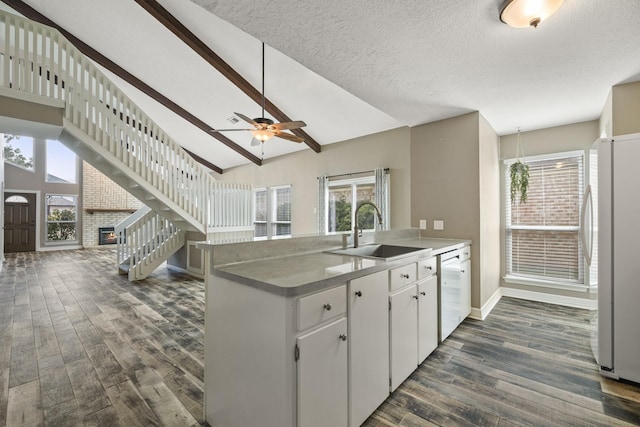 2919 Lake View Dr, Missouri City, TX 77459 - kitchen with white appliances, dark wood finished floors, a peninsula, a fireplace, and ceiling fan