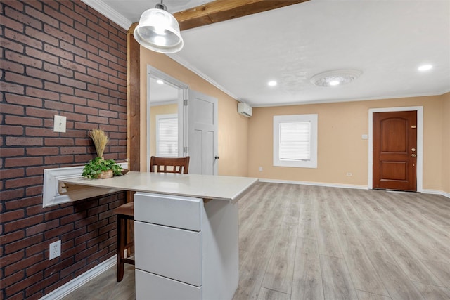 4505 Memorial Dr, Waco, TX 76711 - kitchen with ornamental molding, a kitchen bar, light wood finished floors, brick wall, and light countertops