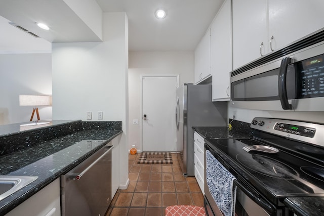 4904 Feagan St Unit 1, Houston, TX 77007 - kitchen with appliances with stainless steel finishes, white cabinetry, dark stone countertops, dark tile patterned flooring, and recessed lighting