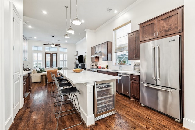 1035 Waverly St Unit B, Houston, TX 77008 - kitchen with appliances with stainless steel finishes, wine cooler, ornamental molding, dark brown cabinetry, and a ceiling fan